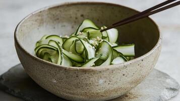 A delicate composition of paper-thin zucchini ribbons in a handmade clay bowl with a raw, unglazed finish. photo