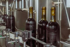 Wine bottles on a production line at a modern winery, showing automated bottling process in industrial environment. photo