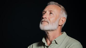 Thoughtful mature caucasian man with gray beard looking upward in studio portrait photo