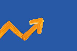 Zigzag upward arrow made with vibrant orange brushstrokes on deep blue background. Represents business growth, success, stock increase or performance improvement in creative way photo