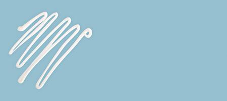 Cream lines drawn on blue background with wide copy space, cream used for skincare, cream texture in minimal composition. Cream adds beauty, softness, and space for product presentation or design photo