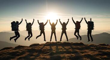 Silhouette of Six Hikers Jumping Joyfully on a Mountain Peak at Sunset photo