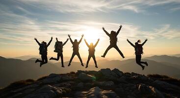 Silhouette of Joyful Hikers Jumping on Mountain Peak at Sunset photo