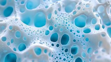 Close-up view of textured foam with air bubbles in various sizes against a light blue background highlighting intricate patterns and vivid colors photo