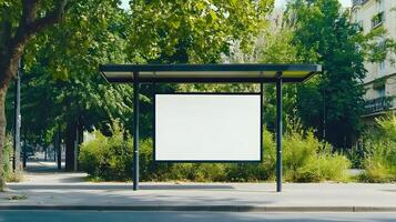 Bus stop shelter surrounded by greenery on a sunny day in a quiet urban area with a blank advertisement board for potential promotion opportunities photo