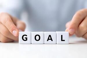 Hands arranging blocks to spell goal during a planning session in a modern workspace photo