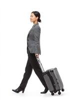 professional Asian businesswoman walking confidently with suitcase, showcasing stylish outfit and determined expression. This captures essence of travel and professionalism photo