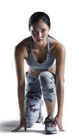 Athletic female runner in starting pose, focused expression, wearing sportswear, preparing for race, showcasing strength and determination photo