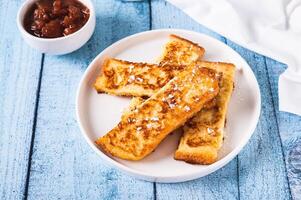 Golden sweet croutons of bread on a plate on the table photo