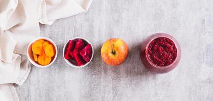 A glass with a mixture of beetroot, apple and carrot juices ABC top view web banner photo