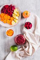 A glass with a mixture of beetroot, apple and carrot juices ABC top and vertical view photo