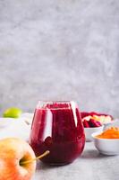 ABC juice from beetroot, carrot and apple for detox in a glass on the table vertical view photo