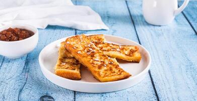 Appetizing croutons in powdered sugar on a plate on the table web banner photo