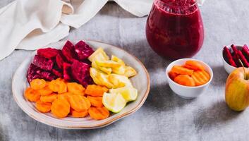 Beetroot, carrot and apple pieces on a plate for making ABC juice on the table web banner photo