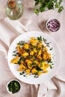 Baked spicy cauliflower with onions and parsley on a plate on the table top and vertical view photo