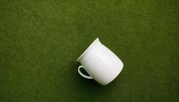 A white cup on a green background photo