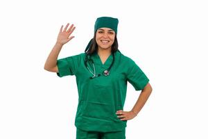 Latin female surgeon waving and smiling on white background photo
