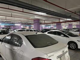 a parking garage with many white cars parked inside in Lahore, Pakistan on January 4, 2025. photo
