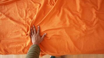 Touching the texture of an orange fabric during a creative session video