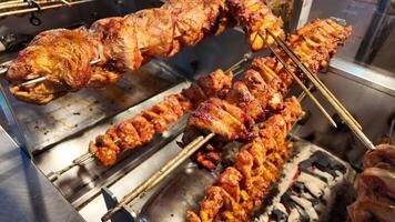 Grilled chicken skewers cooking over charcoal at local eatery video