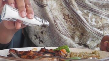 Adding seasoning to grilled chicken at a dining table video