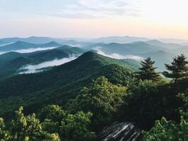 Breathtaking mountain landscape with rolling hills, mist, and trees, capturing the beauty of nature at sunrise. photo