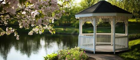 A serene gazebo by a tranquil lake surrounded by blooming trees, embodying nature's beauty and peacefulness. photo