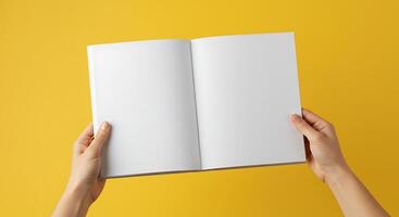 Holding Open Book with Blank Pages on Yellow Background photo