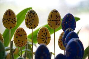 Decorative Easter Eggs on Sticks with Vibrant Yellow and Blue Patterns photo