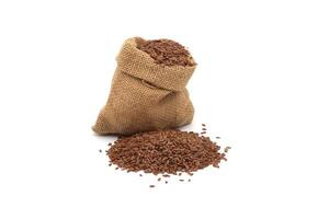 A rustic burlap sack filled with flax seeds, with a small pile of seeds beside it photo
