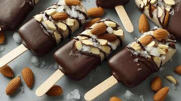 Chocolate Covered Ice Cream Pops with Almonds on a Cool Surface photo