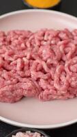 Stuffing or ground raw beef or pork with salt and spices on a black backdrop video