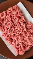 Stuffing or ground raw pork with salt and spices on a black background video