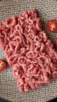 Stuffing or ground raw beef with salt and spices on a black background video
