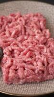Stuffing or ground raw beef or pork with salt and spices on background video