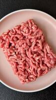 Stuffing or ground raw beef or pork with salt and spices on a black background video