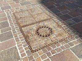 Intricate cobblestone mosaic design on stone pavement with geometric patterns photo