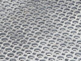 Close-up of worn circular metal grid with repeated hexagonal pattern photo