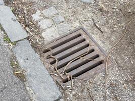 Urban drain with litter highlighting pollution issues in city environment photo