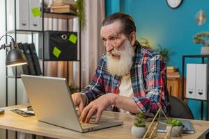 Frustrated senior man having software problems with laptop, angry man get nervous seeing error virus photo
