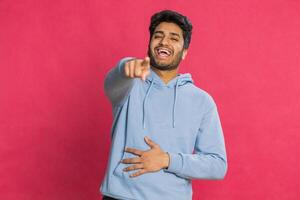 Happy excited Indian man laughing out loud after hearing ridiculous anecdote, reaction on funny joke photo