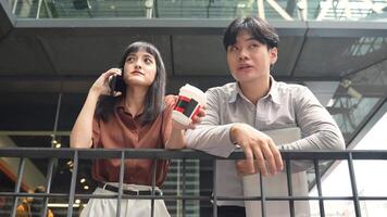 Woman talking on the phone standing with colleague while taking a break in the city video