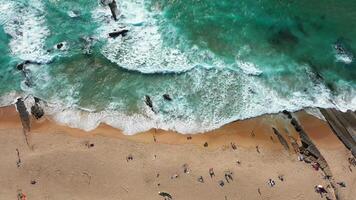 aéreo Visão do ondas falhando em de praia com pessoas desfrutando verão período de férias video