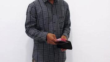 Man In Gray Plaid Shirt Holding Currency And Wallet Against White Background video
