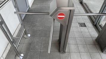 Sleek turnstile gate in modern office building, symbolizing security and access control, relevant for corporate environments and events photo