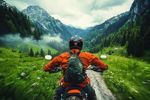 A rider on a motorcycle navigates a winding trail through a vibrant green valley surrounded by majestic mountains. The overcast sky adds a dramatic touch to the exploration. photo