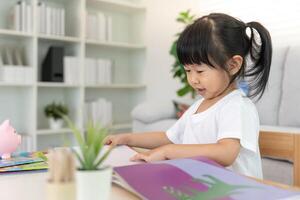 Happy Asian children relax read book at home. daughter and reading a story. learn development, childcare, laughing, education, storytelling, practice, imagine, reduce addiction. photo