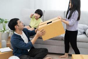 relocation. Family smile and happy after buy new apartment, inside the room was a cardboard box contain personal belongings and furniture. move in the new apartment or condominium photo
