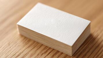 Blank business card stack on wooden surface with natural texture and soft lighting for branding concept photo