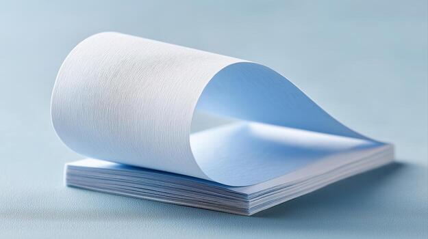Elegant Light Blue Paper Stack with Flowing Sheet for Creative Art and Design Inspiration photo